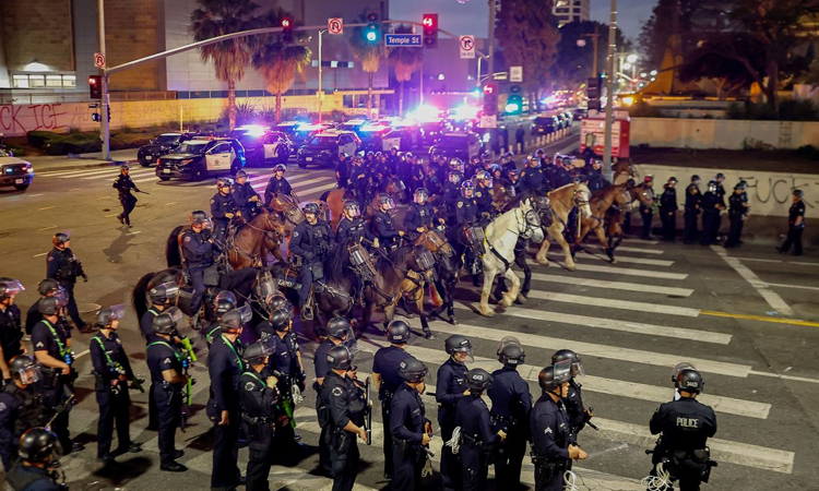 LA police say arrests underway as groups defy curfew
